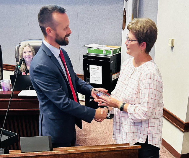 Chairman Chris Slusser congratulates Board of Review member Janis Hagnauer during her retirement recognition. Hagnauer’s last day is Oct. 3.