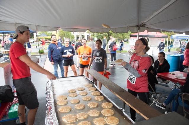 Eileen Martindale catches a pancake during the Cougars Unleashed Homecoming Run and Pancake Breakfast.