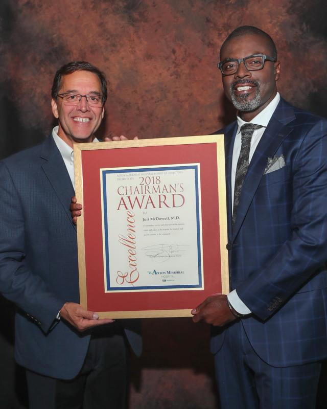 Dr. Juri McDowell, right, accepts Alton Memorial Hospital&rsquo;s 2018 Chairman&rsquo;s Award from Steve Thompson, chairman of the AMH board of directors.