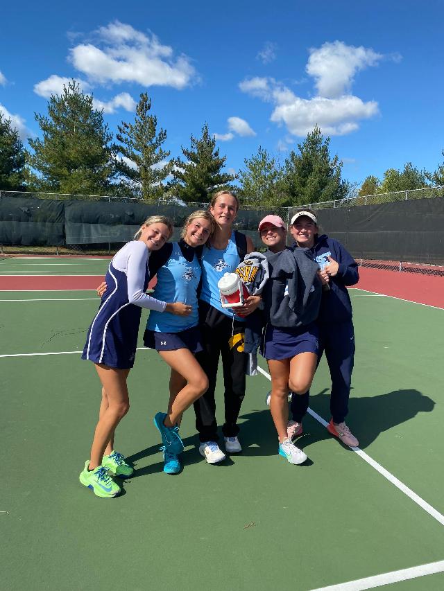 Conference Champion in #5 Singles Kate Hudson (center) being congratulated by teammates after her win.