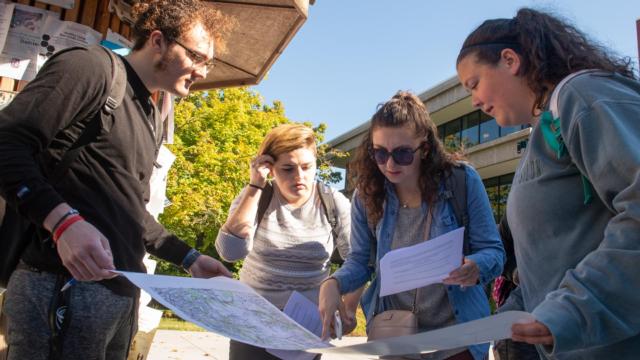 SIUE students use a topographic map to locate an EarthCache on campus.