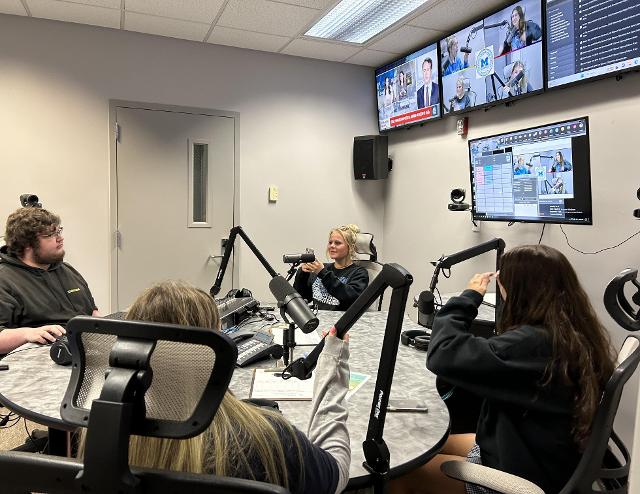 A Lewis and Clark student helps Marquette students record a podcast.