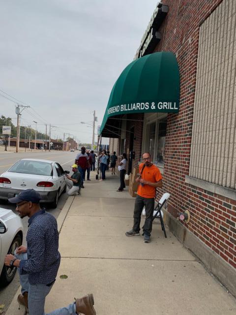 Rev. Jason Harrison takes part in the food giveaway last week at the old Riverbend Billiards building.