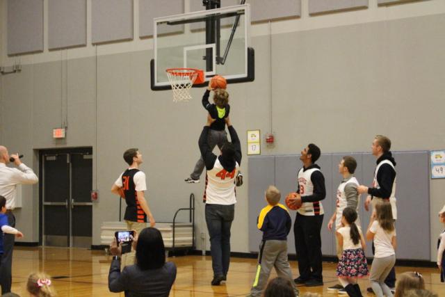 A.J. Epenesa lifts a Goshen Elementary student above his head to make a slam dunk. 