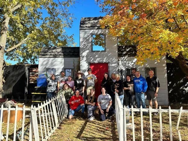 The Mason family smiles with the friends and neighbors who helped build this year's haunted house.