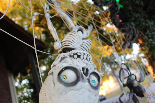 A spooky skeleton is sprawled out on The Halloween House's giant spider web. 
