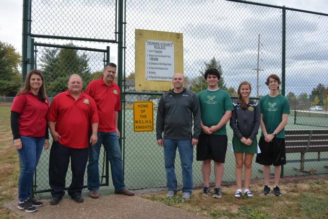 Metro East Lutheran High School tennis reps stand next to a sign that says 