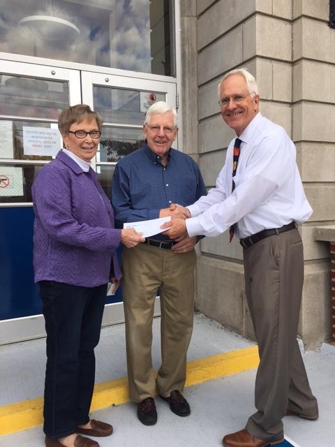 Robert and Alice Reinecke receive the big $50,000 grand-prize check for the Marquette Catholic Mega Raffle from Principal Mike Slaughter.