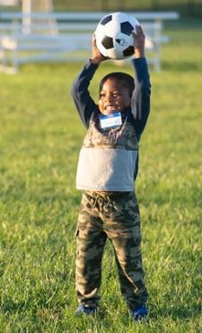 ECC student Jaiden Hayes plays soccer during an outdoor gathering.