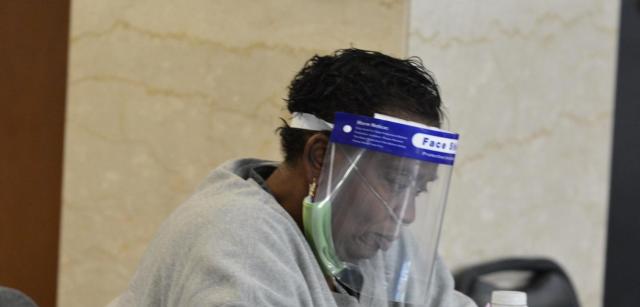 An election judge has on her protective equipment for the day of voting ahead. Masks are required within the polling places.