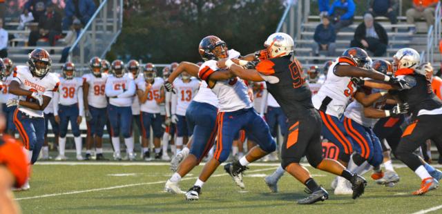 Edwardsville's A.J. Epenesa (No. 99) puts pressure on the quarterback.