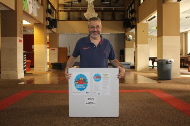 Community Center Director Matt Contarino happily poses inside of the drop-off box located at the RiverBender.com Community Center in Downtown Alton. 