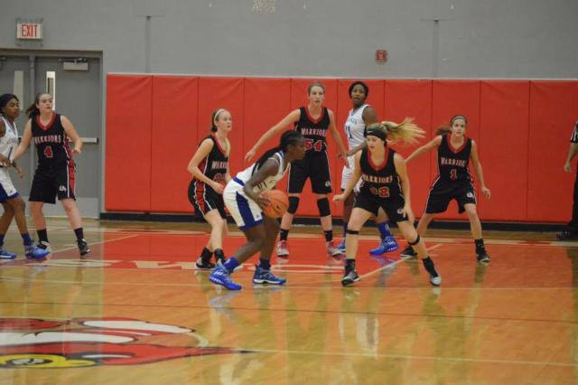 The Warriors' Grace Baalman (center), Jordan Holland (right), Sophie Lorton (right center), Junie Zirkelbach (left center) and Rayna Zirkelbach (left) surround Cahokia's offense during action Monday at Alton. (Photo by Brent Feeney)