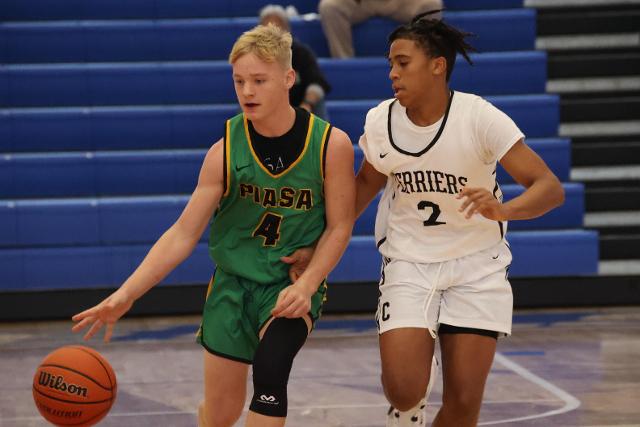Piasa freshman Connor Wood drives past Carbondale freshman Jerrance Howard Wednesday afternoon at the 2023 Hoopsgiving Classic hosted by Roxana High School. (Photo by Brad Piros)