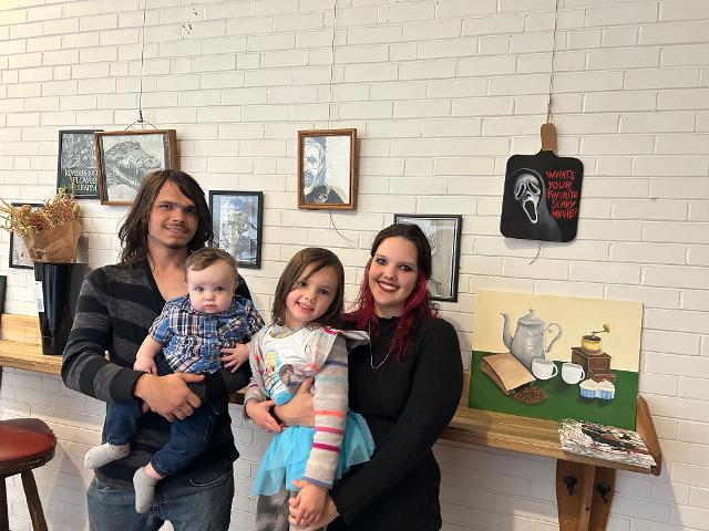 Kaitlyn Koroby and her family pose with her artwork at Milton Schoolhouse.