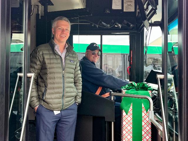 (Left to right): MCT Managing Director SJ Morrison and MCT Bus Operator Scott Thompson, next to a decorated farebox on a 2022 Holiday Bus.