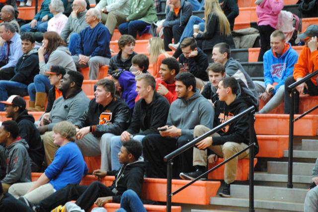 A.J. Epenesa, Caleb Strohmeier, Mark Smith and Oliver Stephen and other Edwardsville varsity boys basketball players sat together to encourage the girls squad on Tuesday against Collinsville.