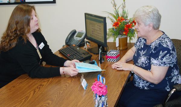 Stacey Loveland of Senior Services Plus visits with a patient at Alton Memorial Hospital about the Care Transitions program.