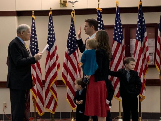 Retired Illinois state senator (2002-2019) and former Madison County state’s attorney (1988 and 2002.) William Haine swears his son, Madison County State’s Attorney Tom Haine, into office. Haine’s wife, Eva, and their four children stand with him as he takes his oath of office.