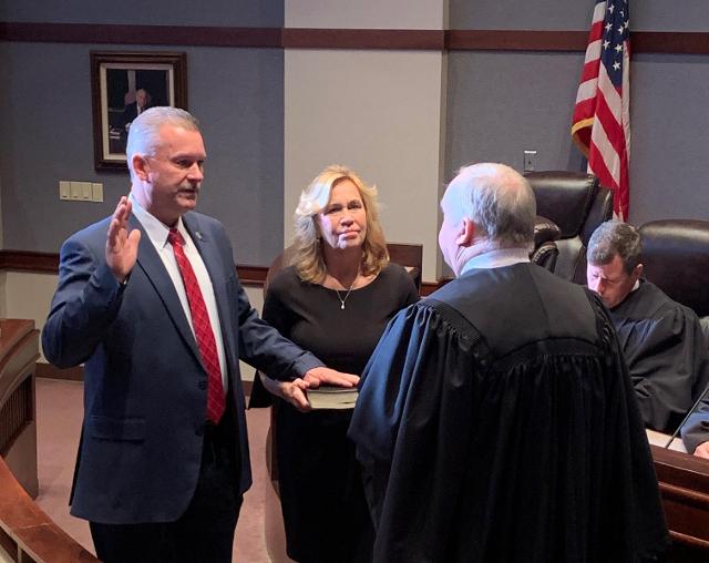 New Madison County Sheriff Jeff Connor takes his oath of office with his wife, Elizabeth, at his side..