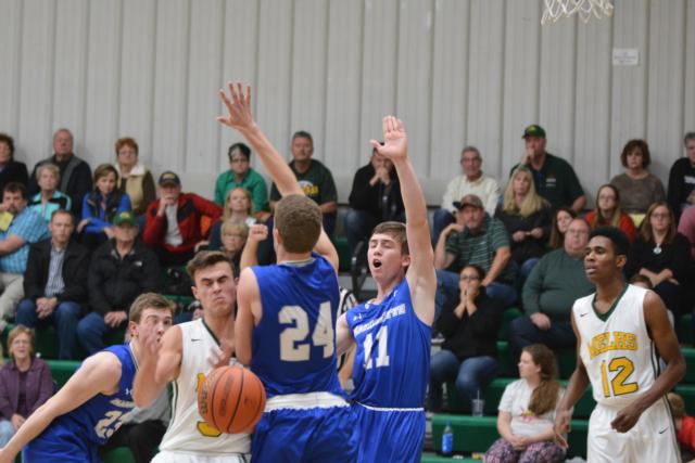 Marquette Catholic's No. 11 Nick Messinger and No. 24 Nick Hemann guard their MELHS opponent Tuesday night. (Photo by Dan Brannan)