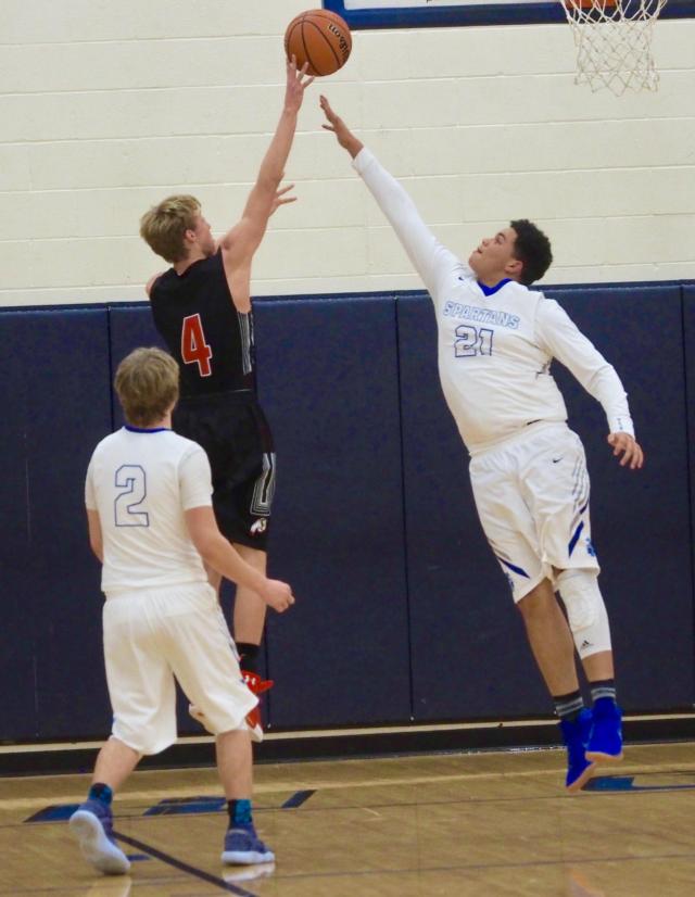 Chandler Sievers attempts a layup, while Zion Thomas tries to block it.