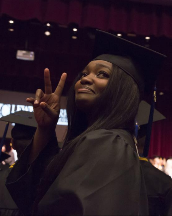  A 2019 graduate of Lewis and Clark Community College acknowledges her guests in the Hatheway Cultural Center&rsquo;s Ann Whitney Olin Theatre during the 48th Annual Commencement, May 15, 2019.