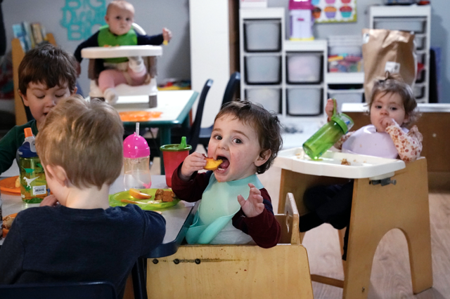 Preschoolers eat lunch at a daycare center.