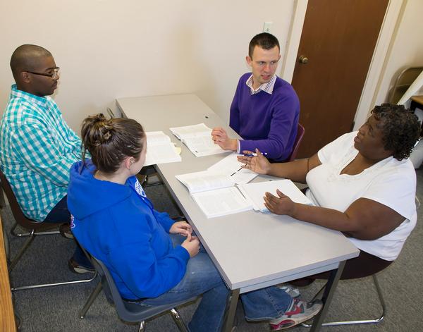 From left, Clevon J. Holmes of Alton, Mallory Roach of Godfrey, Human Services Instructor Chad Keller of St. Louis and Lurnia Ivory of Alton discuss recently completed essays for the human services program. Photograph by Louise Jett, L&C Media Specialist