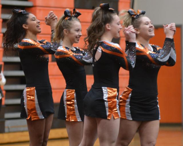 Edwardsville cheerleaders clinch their fists during a cheer, followed by Lincoln Middle cheerleaders in action. (Photos by Dan Brannan)