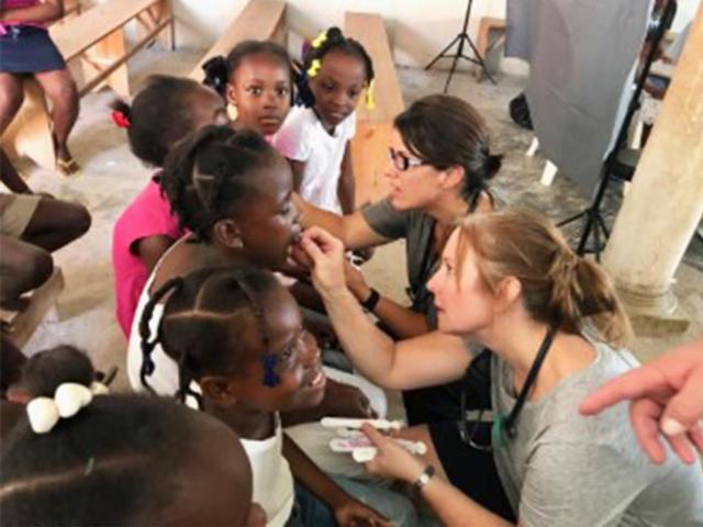 Valerie Griffin, DNP, assistant clinical professor in the SIUE School of Nursing, and nursing graduate student Lorilee Sebesta, apply fluoride to Haitian children’s teeth during their Oct. service trip.