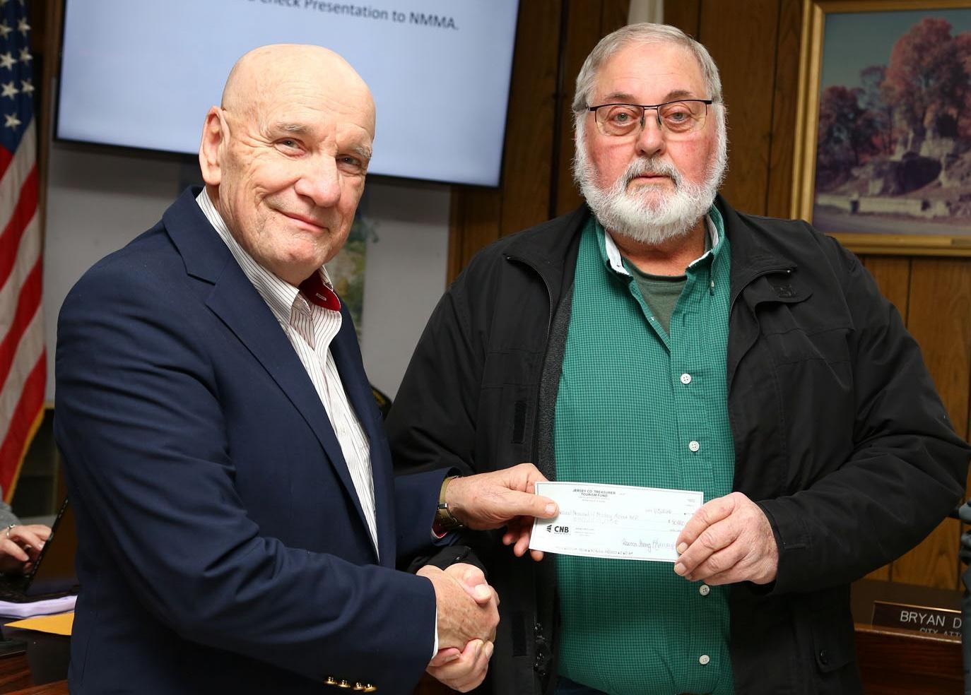 Jersey County Board Chairman Gary Krueger (right) presents Grafton Mayor Mike Morrow (left) with a $50,000 donation towards the National Memorial of Military Ascent.