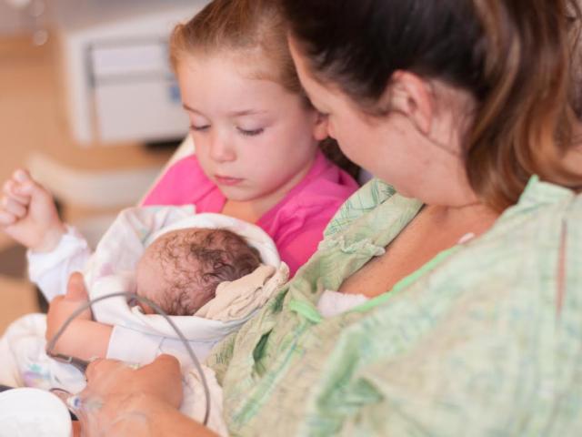 Five year old Maylin Rheude holds her new baby sister for the first time at the Women's Pavilion at OSF Saint Anthony's Health Center.
