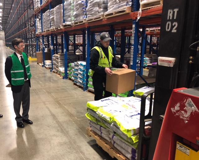 Madison County Board Chairman Kurt Prenzler (left) watches as an employee at Royal Canin distribution facility at Gateway Commerce Center loads a box onto a pallet. Prenzler and other county officials recently toured Gateway and learned about the expansion of businesses and potential new ones coming to Madison County.