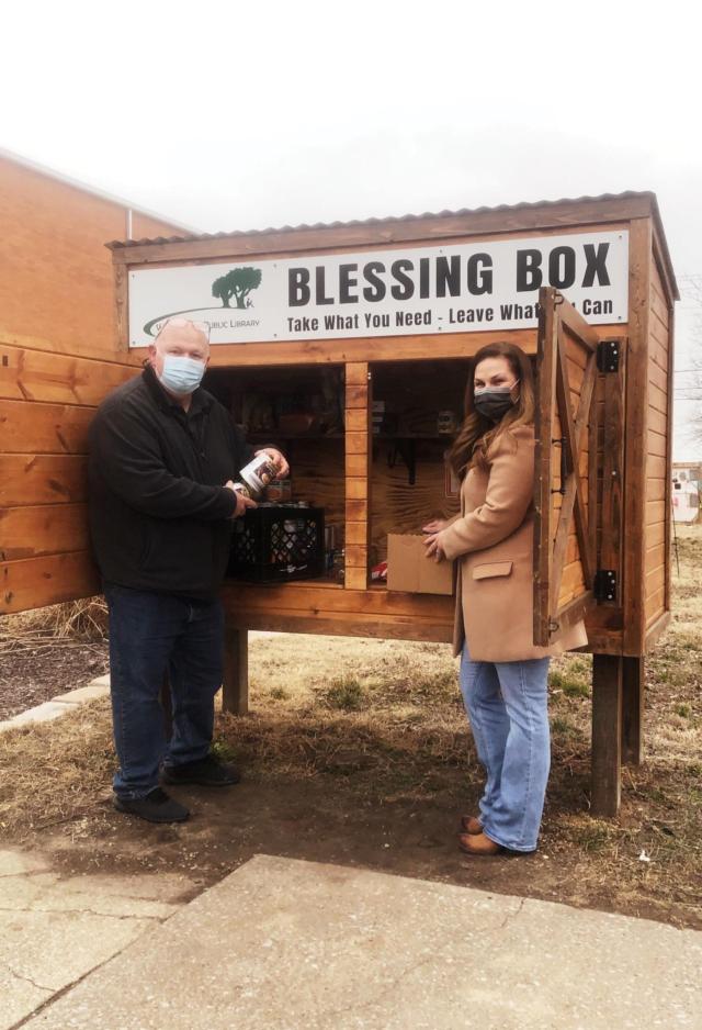 Councilman Mike Anderson (left) and Senator Rachelle Crowe (right) take canned goods to the Wood River Public Library&rsquo;s Blessing Box