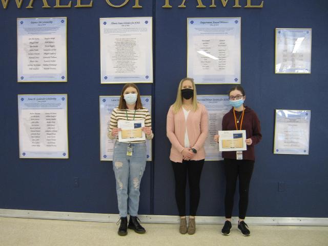 Katreona Benedict, freshman (left) and Abigail Behl, eighth grader (right) are being congratulated by Amber Millburg (center) of CNB Bank & Trust.