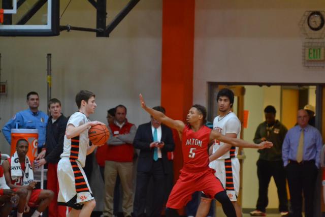 Oliver Stephen takes the ball against Alton opponent Lavonte Hobbs as A.J. Epenesa stands in the background.