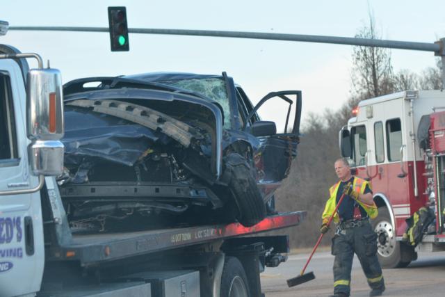 An Alton Fire Department member helps clean up the area where the accident occurred Monday. (Photo by Dan Brannan)