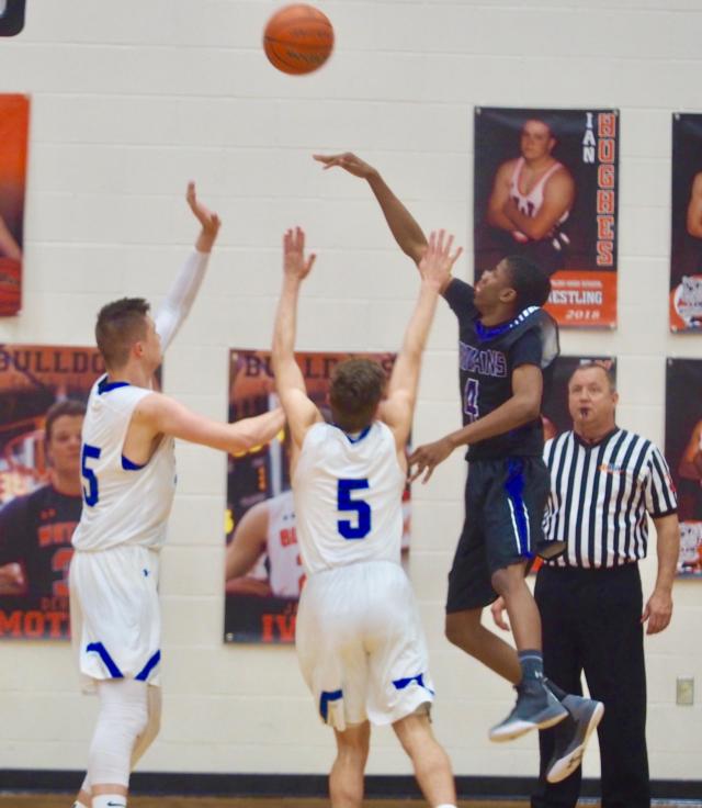 Jake Hall (25) and Chris Hartrich (5) try disrupt Jarred Johnson (4) as he attempts an off-balance layup.