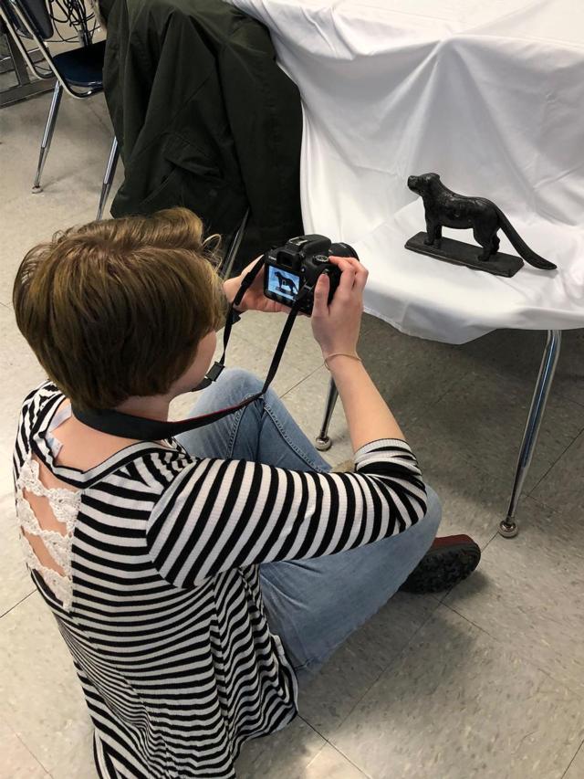 SIUE student Lillian Stevens photographs an artifact brought in by a Liberty Middle School student.