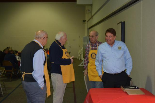 Dale Neudecker, left, joins a group of men in conversation during the Alton-Godfrey Rotary Club Chili Chowdown on Monday.