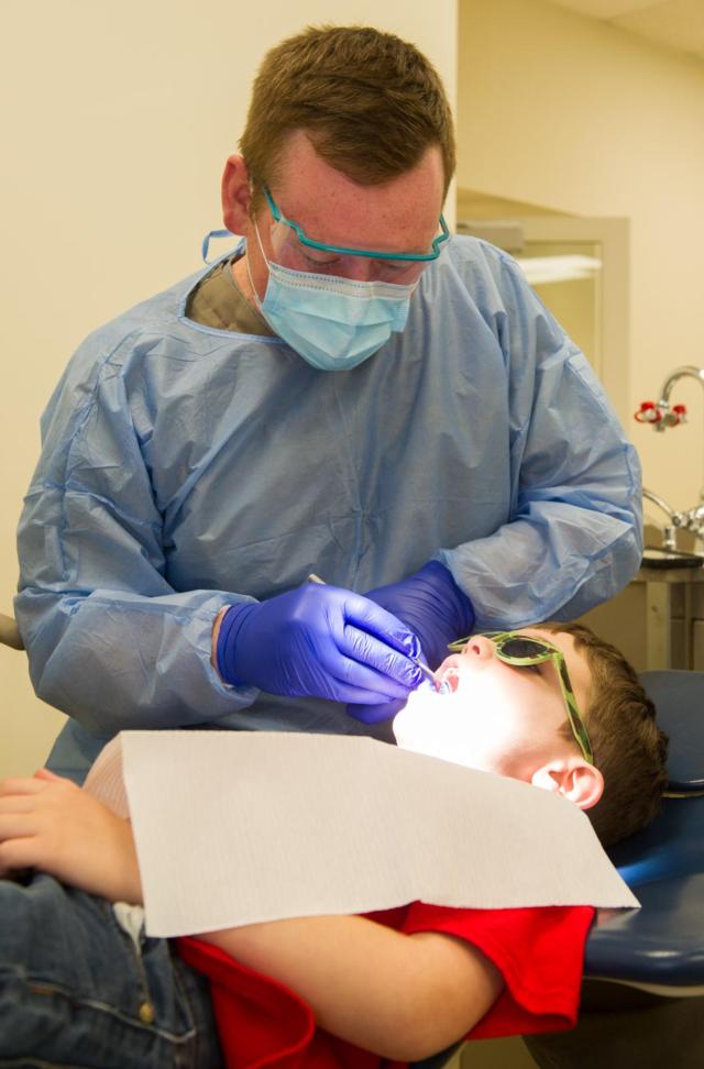 SIU SDM fourth-year student Josh Welborn performs a dental screening on a kindergarten student during National Children’s Dental Health Month.
