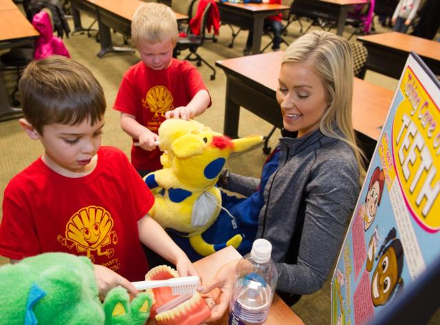 SIU School of Dental Medicine third-year student Kelsie Vandergriff teaches kindergarten students from Roxana how to brush and floss.