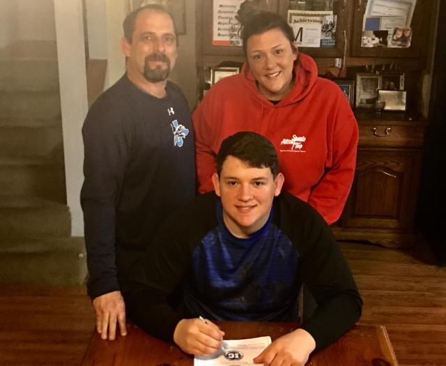 Rhylon DeSherlia has signed with Illinois College to play football. He is shown with his parents.