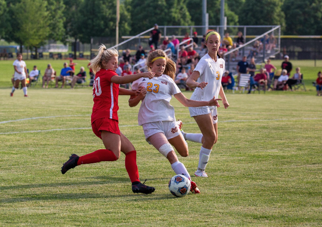 Abrianna Garrett (23) tries to get past a Triad defender in a contest played last season. Garret scored three goals in this season's opener against Breese Central. (Photo by Randy Manning)