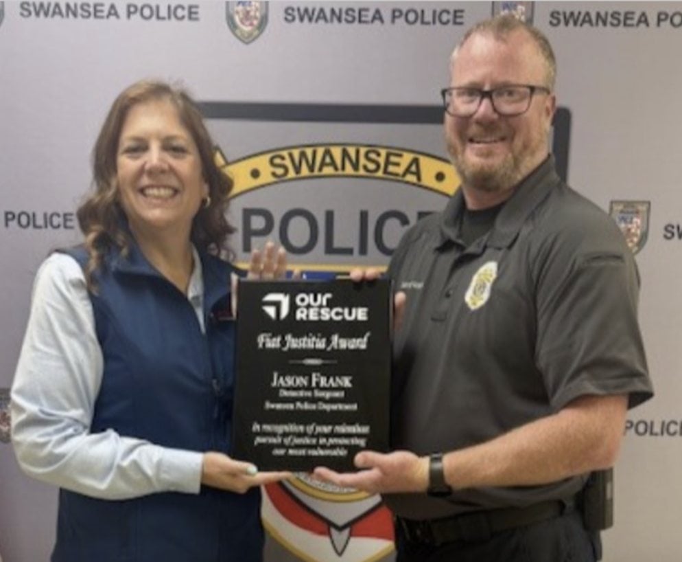 Swansea Trustee Natalie Jablonski presents an award to Det. Sgt. Jason Frank of the Swansea Police Department.