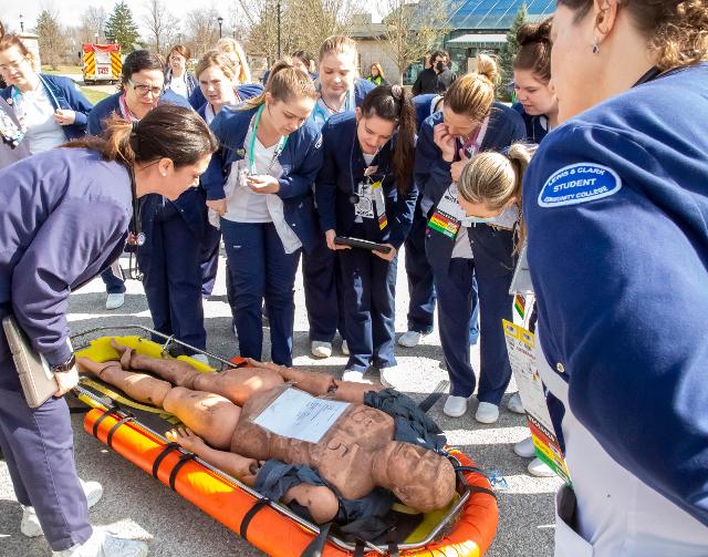 L&C Nursing students gather around a “victim” (a practice dummy) during Friday’s mock disaster exercise on the college’s Godfrey Campus. Photo by Jan Dona, L&C Marketing & PR