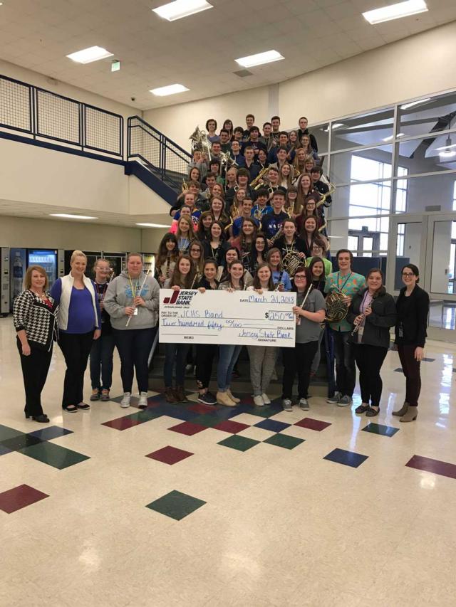 The Jersey Community High School band shows off their $250 check after coming in first place.