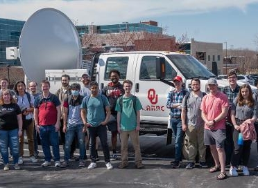 SIUE students and faculty, and collaborators from the University of Oklahoma, gather near a mobile radar unit that was hosted on campus.