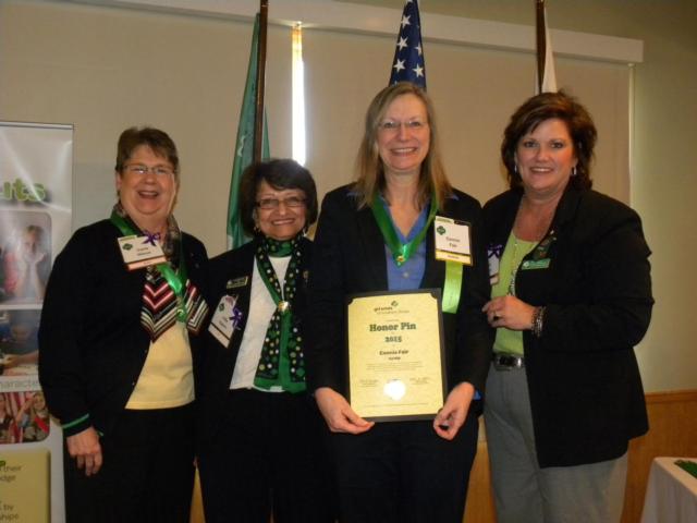 Connie Fair (center) receives her Girl Scout Honor Pin from (left to right) Carla Nilson, GSSI Board of Director member; Villie M. Appoo, GSSI CEO; and Linda Manley, GSSI Board of Director Chair.
